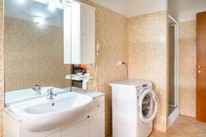 a bathroom with a sink and a washing machine at Aria in Follonica +13 photos