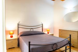a bedroom with a bed with two lamps and two dressers at Aria in Follonica