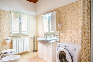 a bathroom with a washing machine and a sink at Aria in Follonica