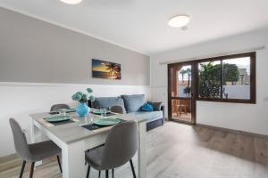 a dining room and living room with a table and chairs at Horizon blu in Corralejo