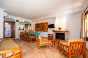 a living room with a table and chairs and a fireplace at Sa Torre ii in Canyamel