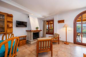 a living room with a table and a fireplace at Sa Torre ii in Canyamel