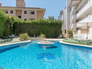 a swimming pool with a fountain in the middle of a building at Sa Torre ii in Canyamel