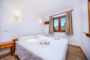 a bedroom with a white bed and a window at Sa Torre ii in Canyamel +27 photos