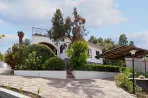 a white house with trees and bushes at Villa Matteo Suite in Porto Columbu - Perdʼe Sali