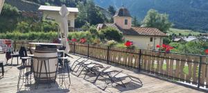 a balcony with chairs and a table and a church at Gîte Le Cembro 6 personnes in Termignon
