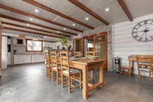 a kitchen with a wooden table and chairs and a clock at Gîte Le Cembro 6 personnes in Termignon