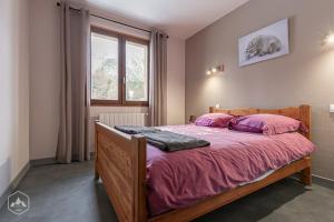 a bedroom with a bed with pink sheets and a window at Gîte Le Cembro 6 personnes in Termignon +16 photos