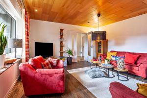 a living room with red couches and a tv at Haus Frigger in Olsberg