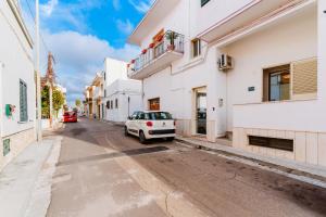 a white car parked on a street between two buildings at Casa Margherita in Matino