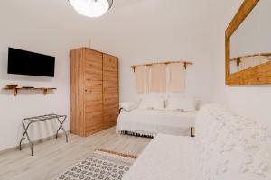 a white room with a bed and a mirror at Casa Margherita in Matino