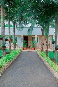 a house with palm trees and a driveway at Rhovee Homes in Moshi