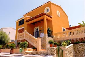 a yellow house with a fence in front of it at Villas2meet Los Geranios in Cala Romàntica