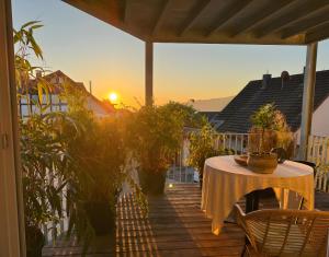 a table on a deck with the sunset in the background at Seeapartment Höri in Gaienhofen