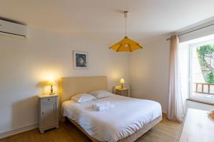 a bedroom with a white bed with two night stands at Maison en pierre piscine clim in Varennes +24 photos