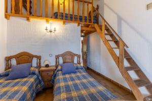 two beds in a room with a loft at La Cárcava in La Serna del Monte