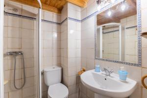 a bathroom with a toilet and a sink and a shower at La Cárcava in La Serna del Monte +31 photos