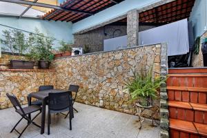 a patio with a stone wall and a table and chairs at Jm Stay in Aveiro
