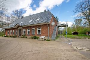 a red brick house with a bench in front of it at Ferienwohnung Coni in Langballig