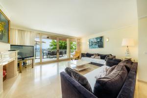 a living room with a couch and a television at Olympo in Port de Pollensa