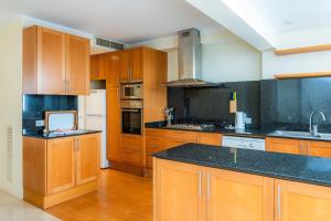 a kitchen with wooden cabinets and black counter tops at Olympo in Port de Pollensa