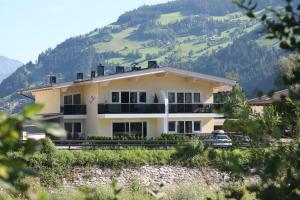 um edifício com uma montanha ao fundo em Alpen-Apart em Schwendau