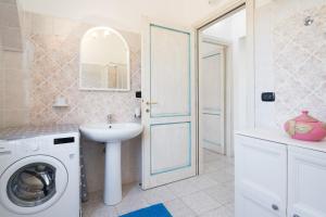 a bathroom with a washing machine and a sink at Villa Sa Mela 28 in Orosei +20 photos