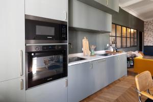a kitchen with white cabinets and a microwave at Charmant appartement centre Ajaccio in Ajaccio