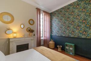 a bedroom with a fireplace and a painting on the wall at Charmant appartement centre Ajaccio in Ajaccio
