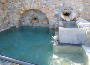 a large pool of water with a stone wall at Agriturismo Bricco in Finale Ligure