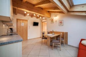 a kitchen and dining room with a table and chairs at Tonigbauernhof Enzian in Schenna