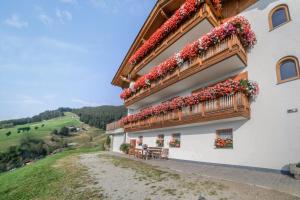 a building with flowers on the side of it at Tonigbauernhof Enzian in Schenna +20 photos