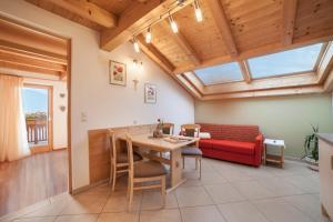 a living room with a red couch and a table at Tonigbauernhof Enzian in Schenna