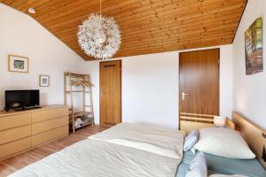 una camera da letto con un letto e un lampadario di Klug a Schonach