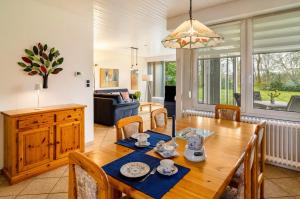 a dining room and living room with a wooden table at Ferienhaus 'am Gänsepfad' in Hage