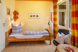 a small bedroom with a bed and a chair at Ferienhaus 'am Gänsepfad' in Hage