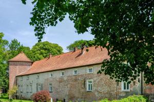 an old brick building with a red roof at Ferienhaus 'am Gänsepfad' in Hage