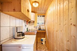 a kitchen with wooden walls and a counter with a microwave at Bungalow 12 - Finnhütte in Niesky