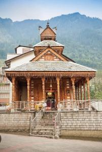 a large wooden building with steps in front of it at MHA hotels MOORANG mall manali in Manāli