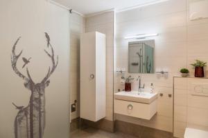 a bathroom with a sink and a shower with a tree on the wall at Apartment Bergglück Stummerberg in Stummerberg +20 photos