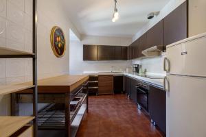 a kitchen with a white refrigerator and a wooden table at Very Elegant Historic Apartment F2 in Gravedona +27 photos