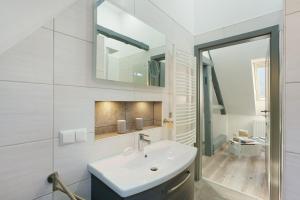 a white bathroom with a sink and a mirror at Ferienwohnung Sophie in Lauchhammer +21 photos