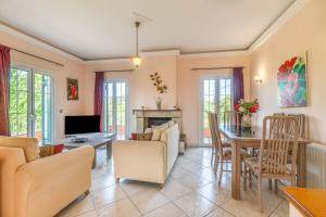 a living room with a fireplace and a dining room at Even Ezer with private pool in Pouládes