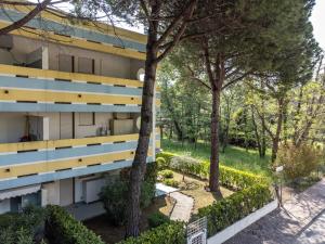 an apartment building with trees in front of it at Appartamento Passeggiata al Mare in Bibione