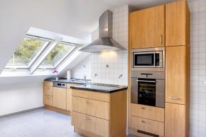 a kitchen with wooden cabinets and a stove top oven at Ferienwohnung Schliestädt in Wellerode