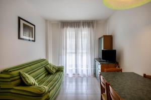 a living room with a couch and a table at Appartamento Passeggiata al Mare in Bibione