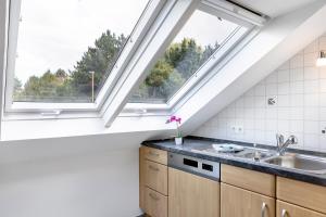 a kitchen with a window and a sink at Ferienwohnung Schliestädt in Wellerode +14 photos