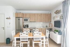 a kitchen and dining room with a wooden table and chairs at Luxury apartment in Cómpeta in Cómpeta
