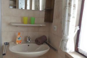 a small bathroom with a sink and a mirror at Ferienwohnung Nordenau in Schmallenberg +8 photos