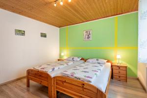 a bedroom with two beds and a wooden ceiling at Ferienwohnung Gruber in Bodenwöhr
